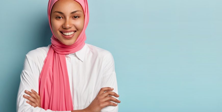 studio-shot-cheerful-religious-muslim-woman-keeps-arms-folded-smiles-broadly-has-white-teeth.jpg